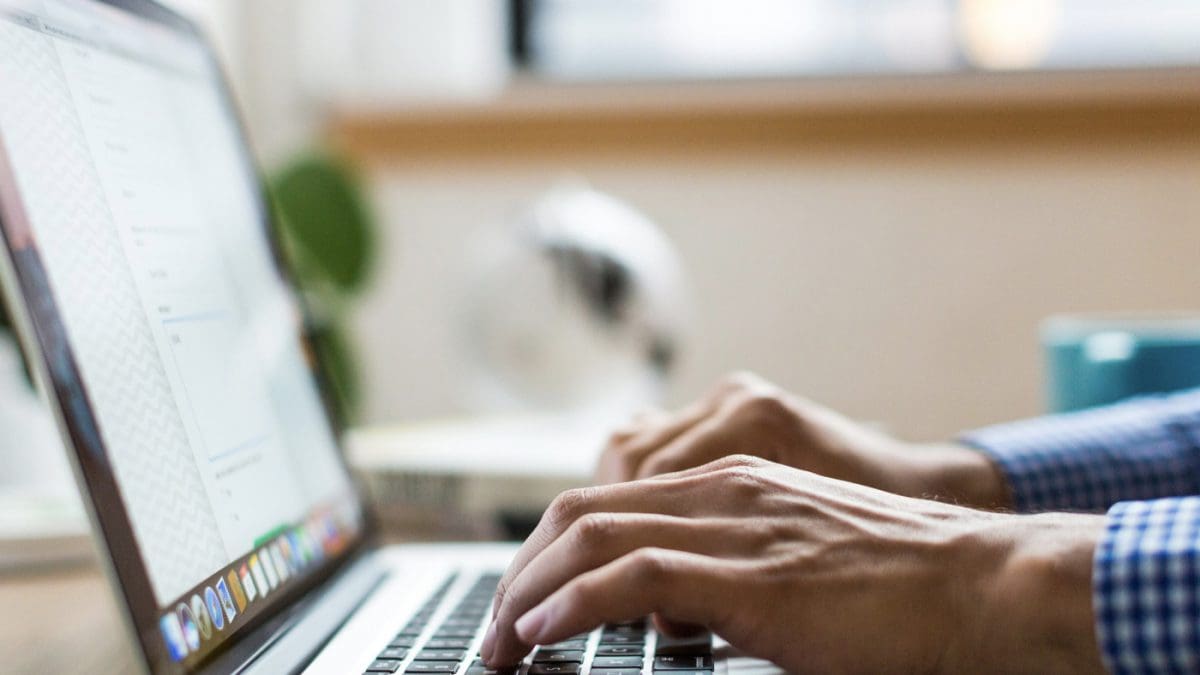 hands typing on a laptop