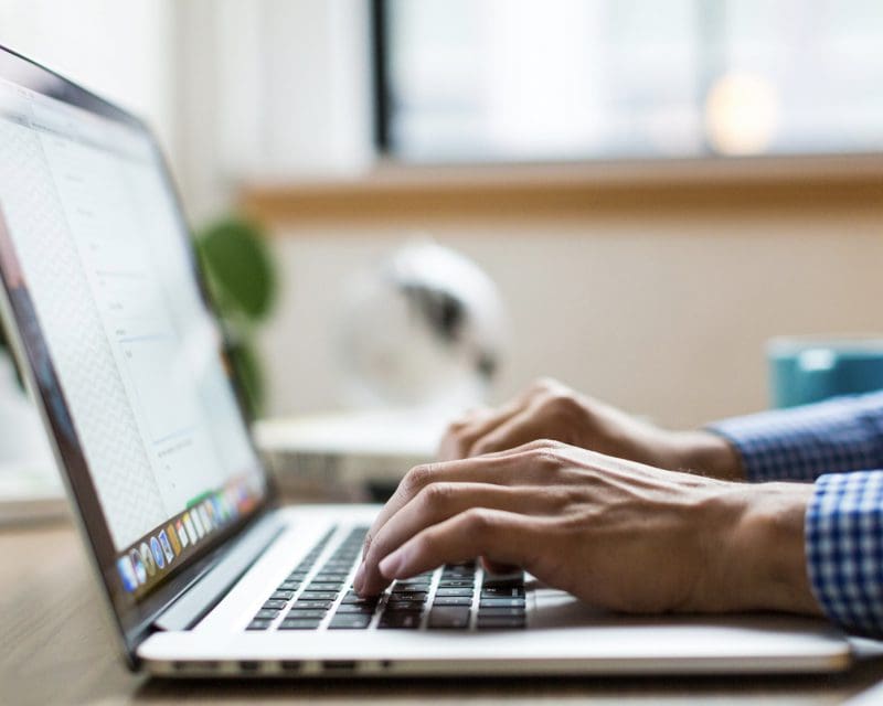 hands typing on a laptop