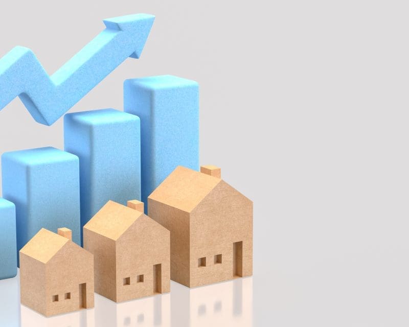 An illustration of houses with a graph behind them