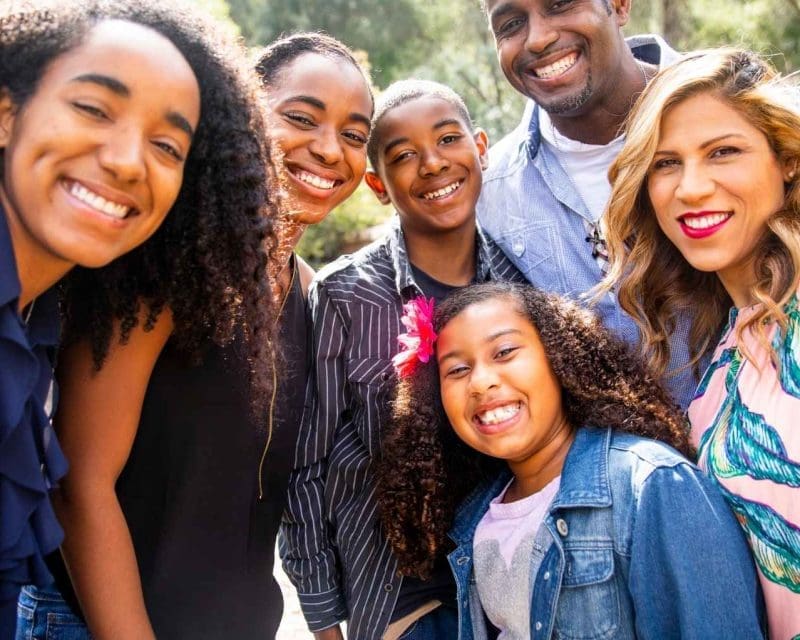 A smiling family six posing the camera