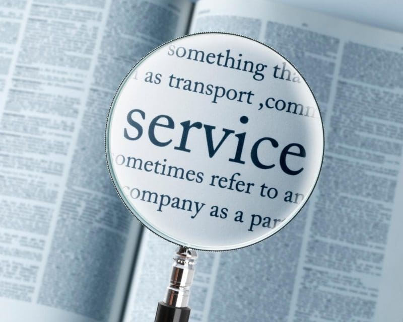 a book with a magnifying glass in the middle of the page, the magnifying glass is focused on the word service