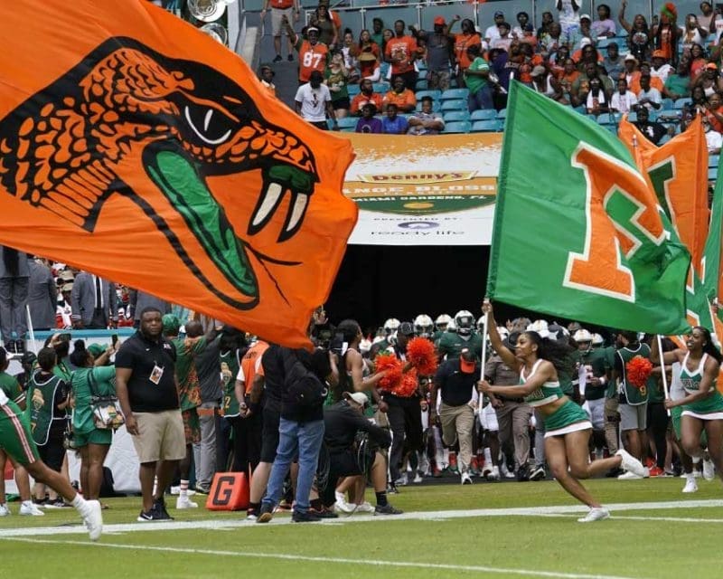 A cheerleader with a flag runs across a football field for FAMU in Tallahassee, Florida